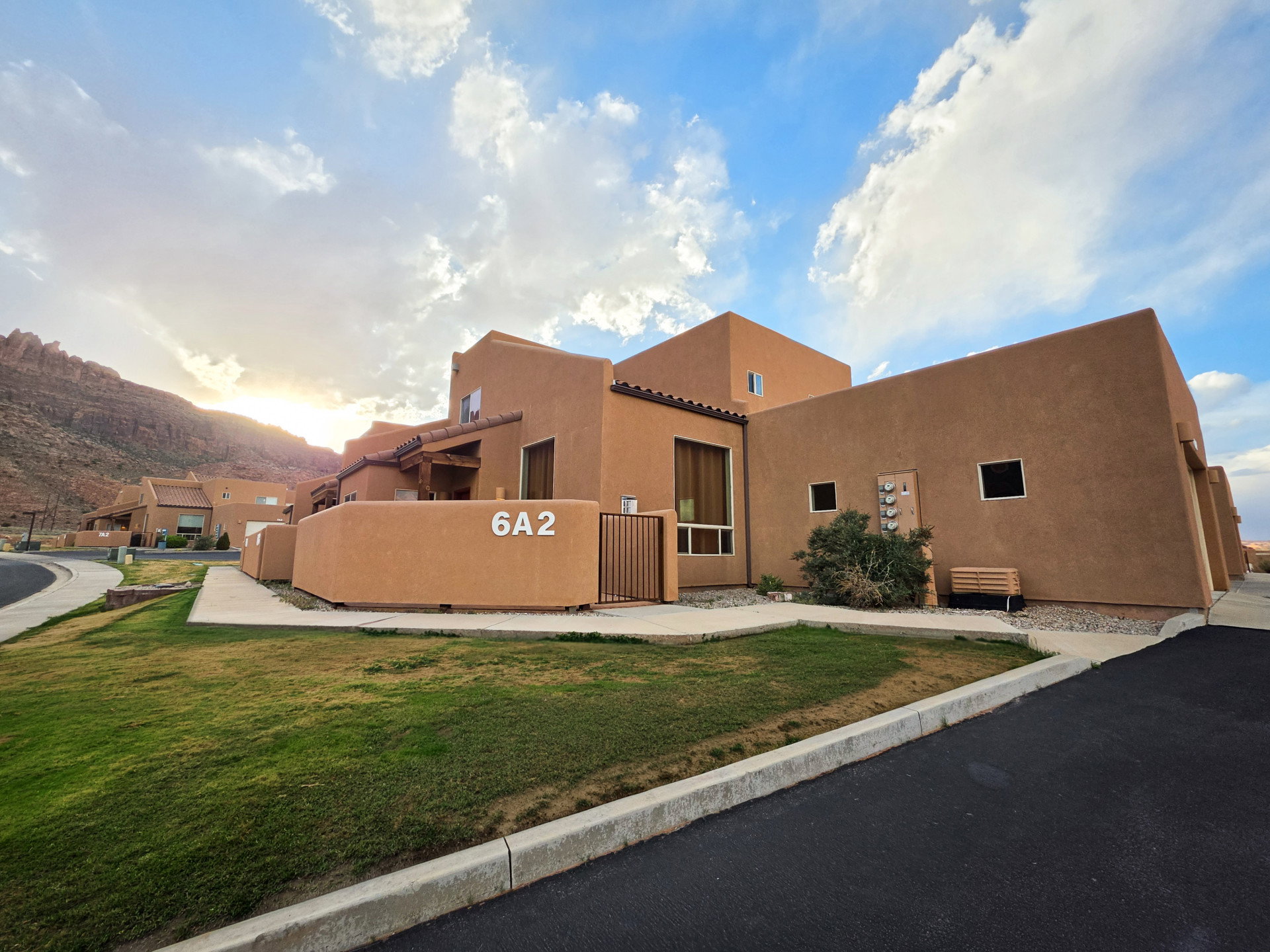 View of front of property with stucco siding, a front yard, a mountain view, and a tile roof
