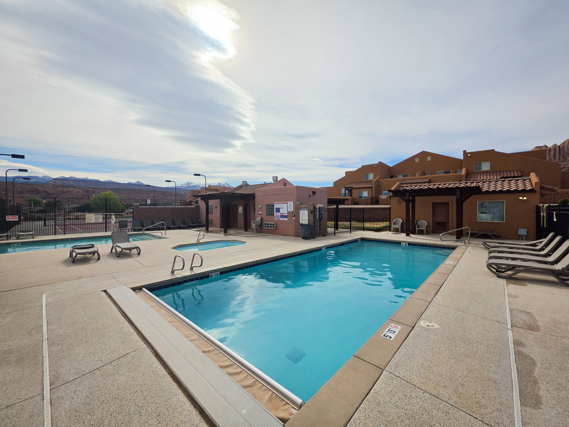 Community pool area featuring a rectangular swimming pool, a second smaller pool, and a jetted spa