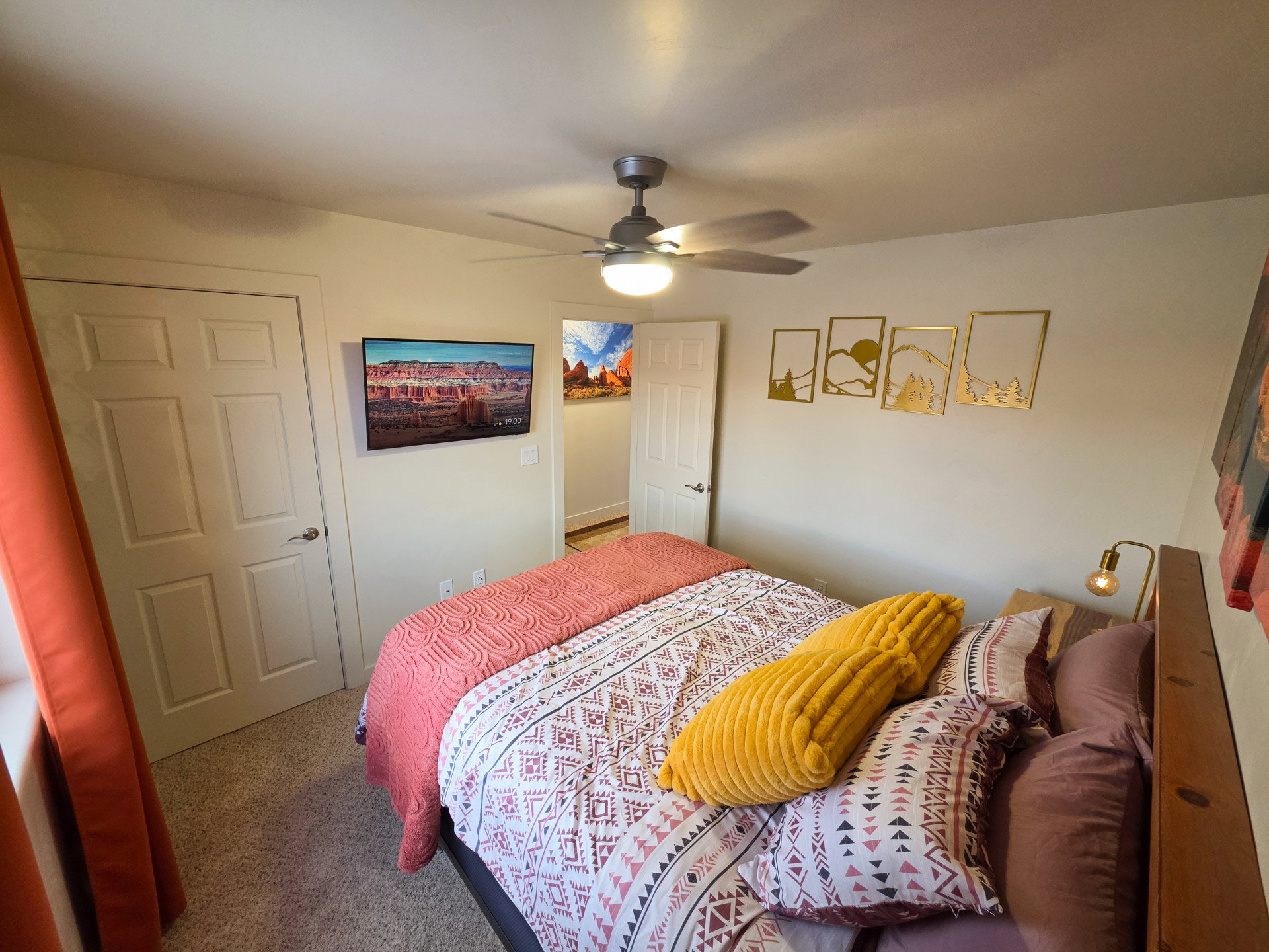 Bedroom featuring carpet flooring, a ceiling fan with integrated lighting, and a paneled door