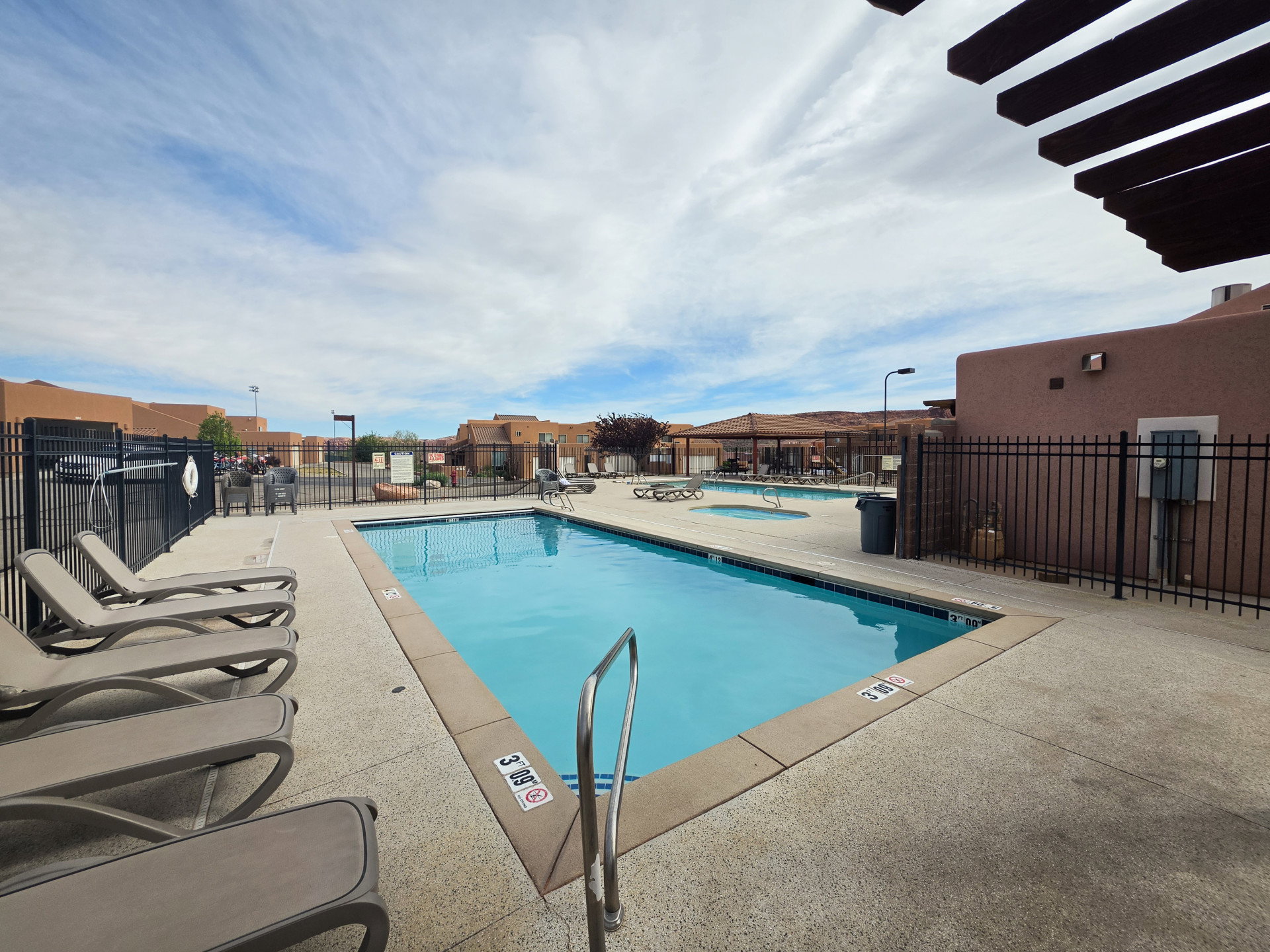 Outdoor swimming pool with integrated spa and surrounding lounge area
