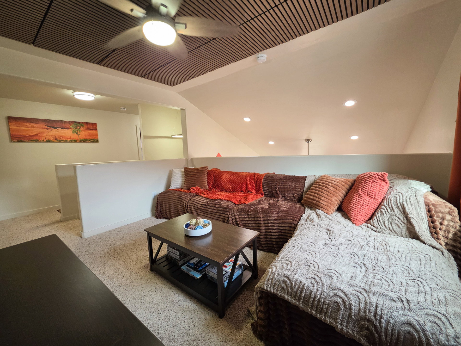 Loft area featuring a slatted wood ceiling, recessed lighting, and a ceiling fan