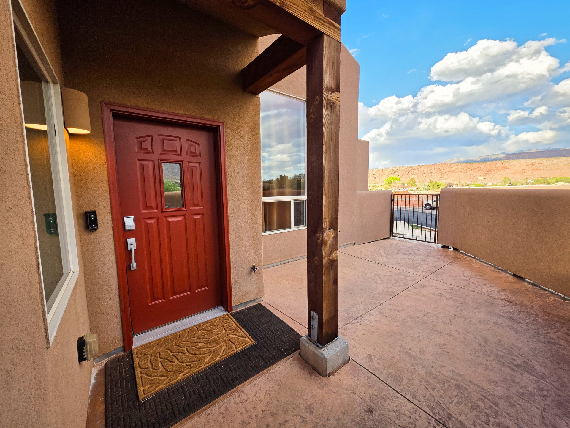 Doorway to property featuring stucco siding and a gate