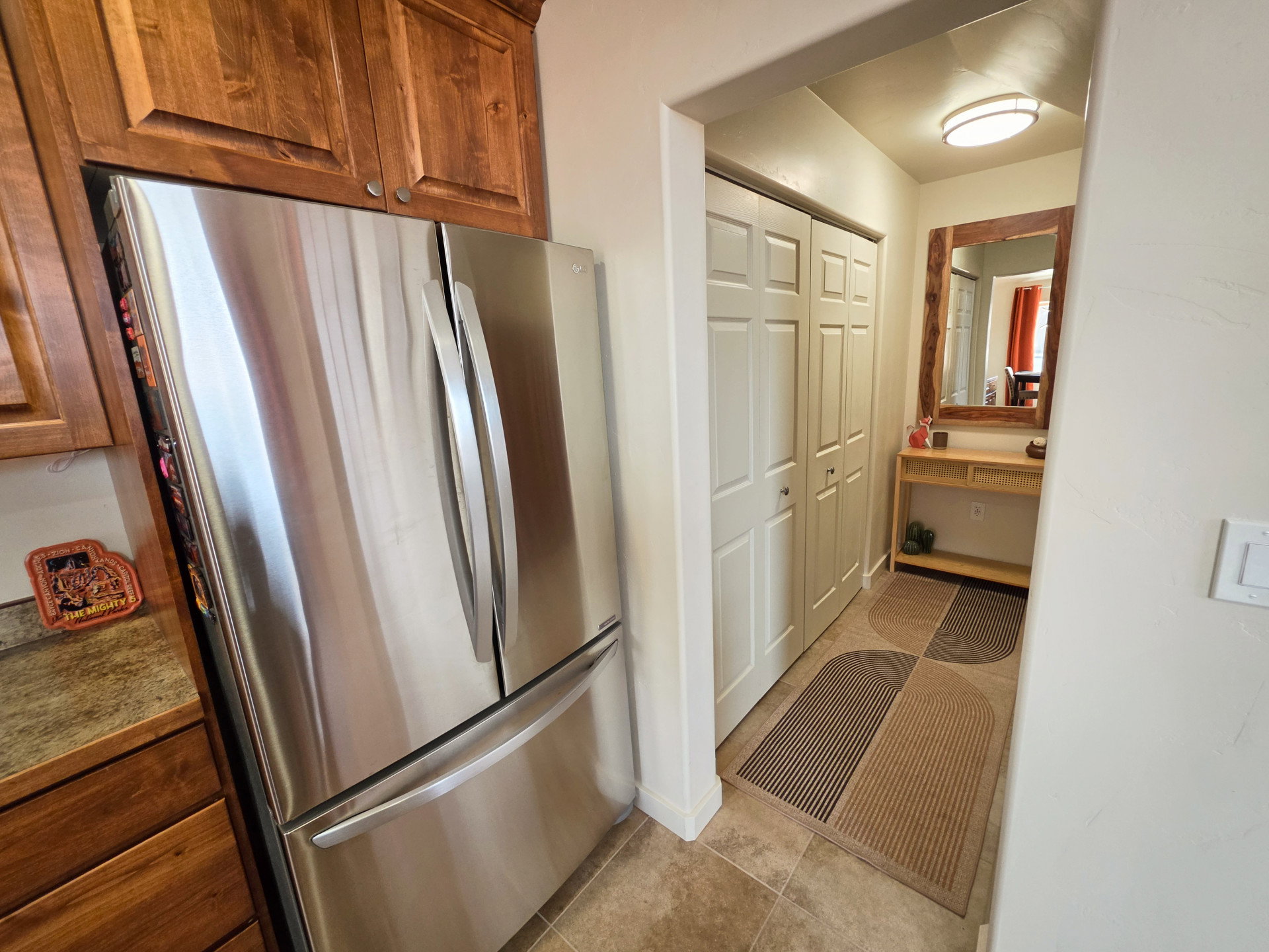 Stainless steel refrigerator complemented by wood cabinetry and stone-finish countertops