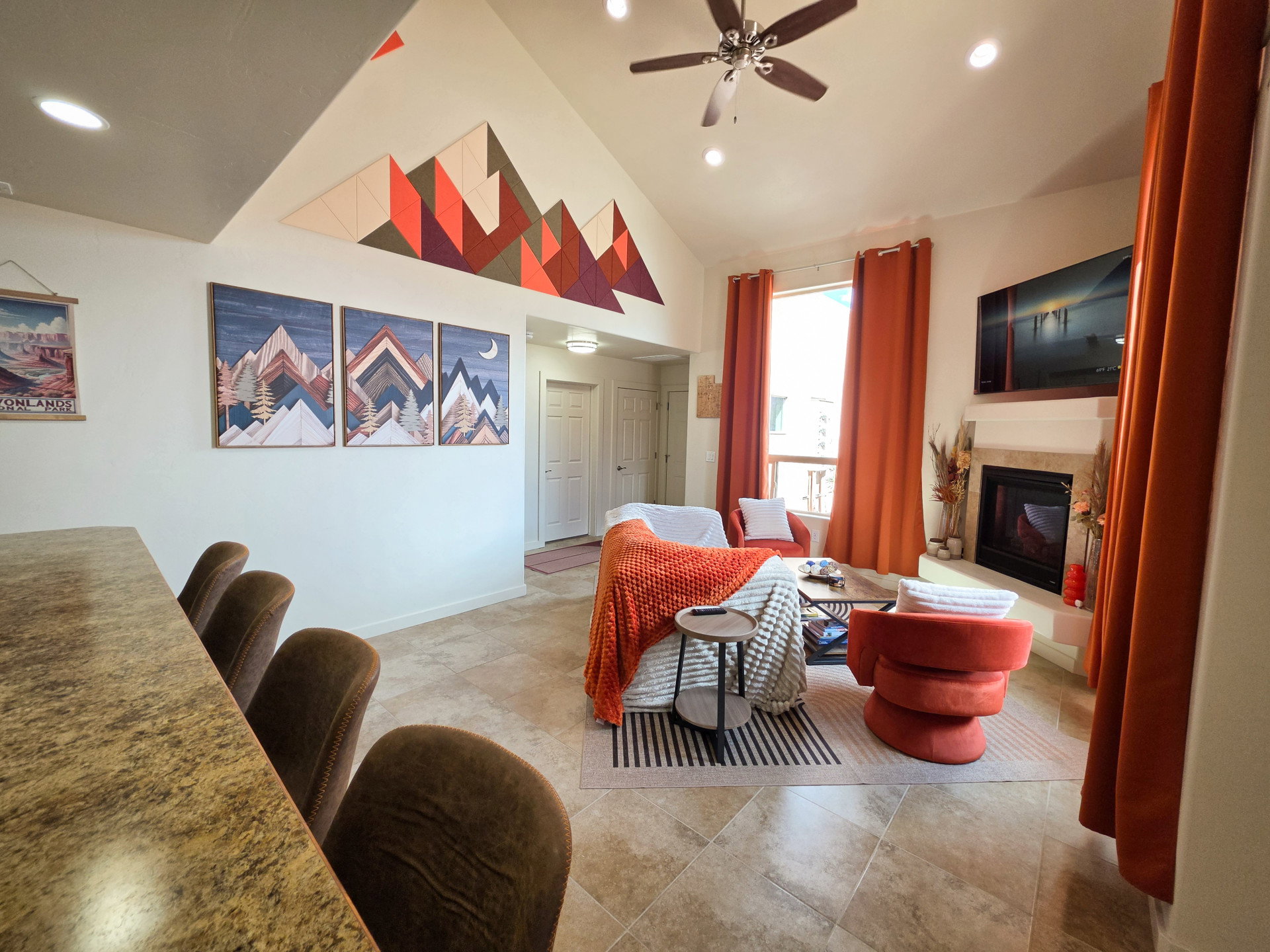 Vaulted ceiling living room featuring a ceiling fan, recessed lighting, and a fireplace with a stone surround