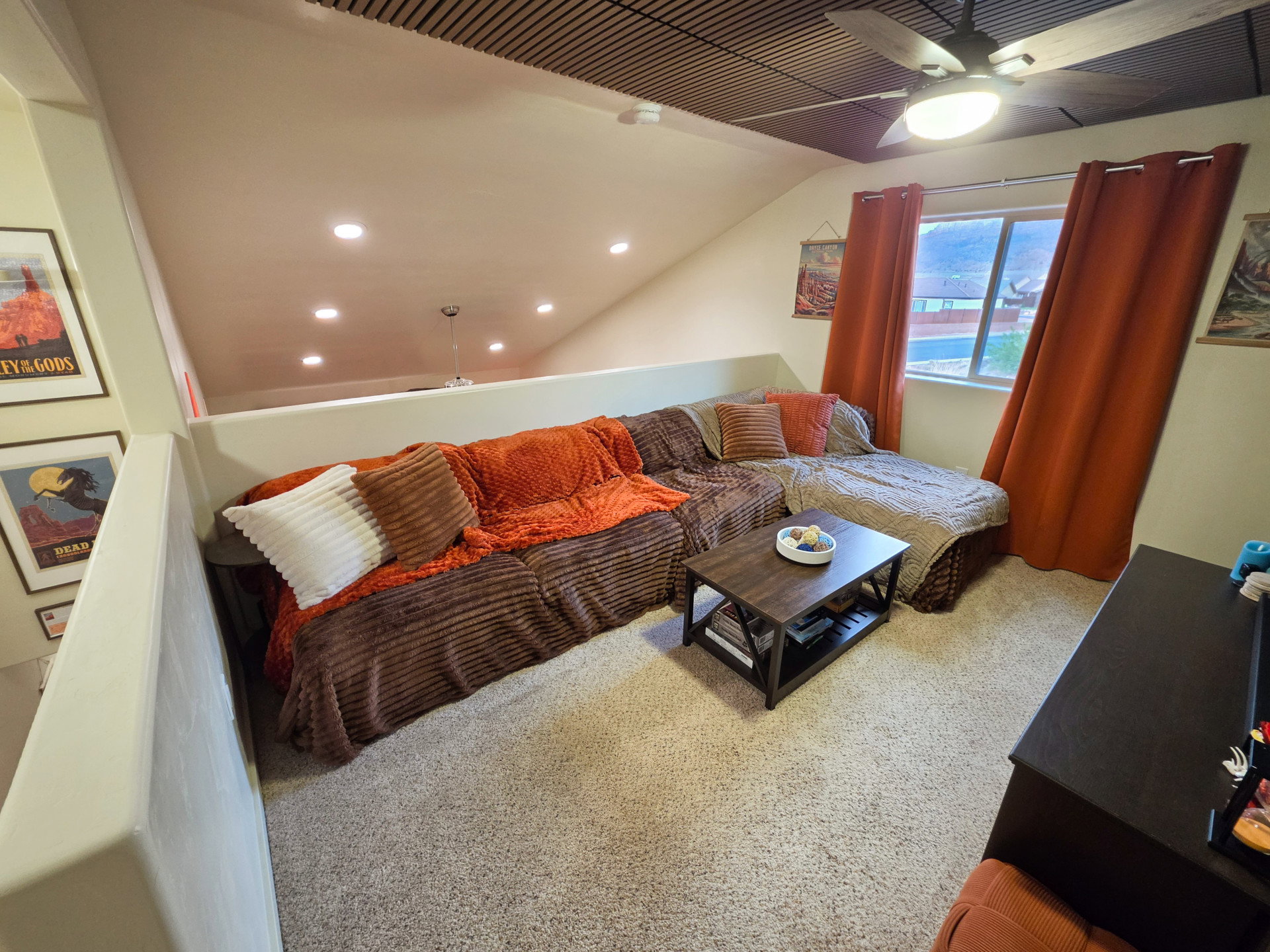 Carpeted loft area featuring a sloped ceiling with recessed lighting and a ceiling fan