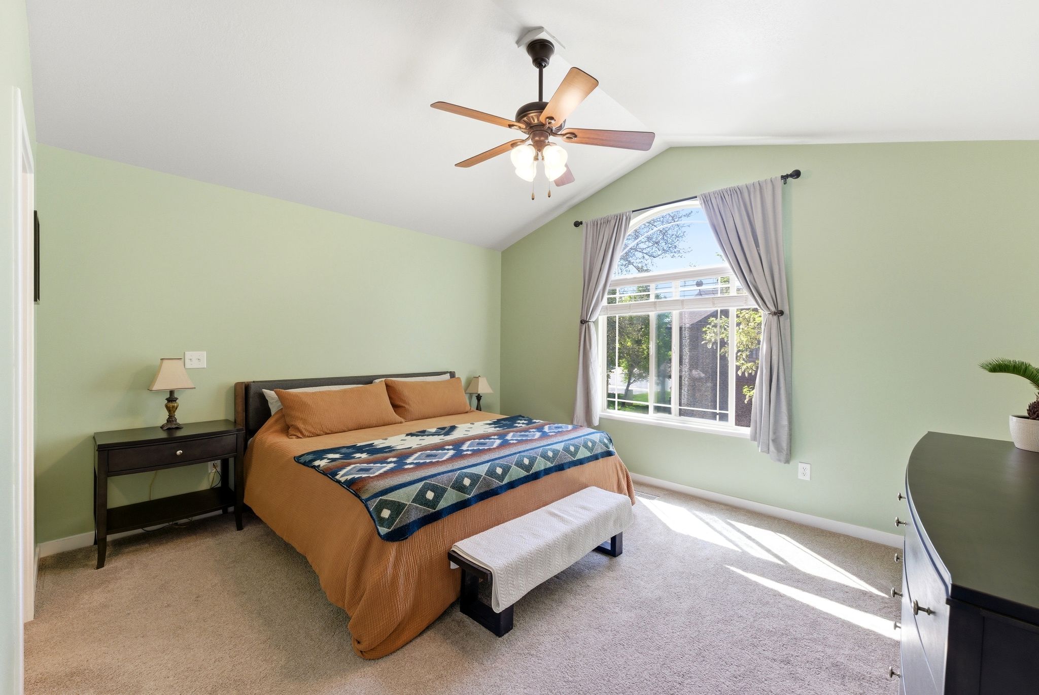 Bedroom with light carpet, lofted ceiling, and a ceiling fan