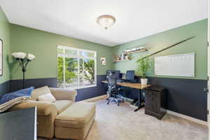 Office area featuring light carpet and baseboards