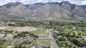 Aerial view of property and surrounding area with nearby suburban area and a mountain backdrop