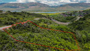 Aerial overview of property's location with property boundaries highlighted and a water and mountain view