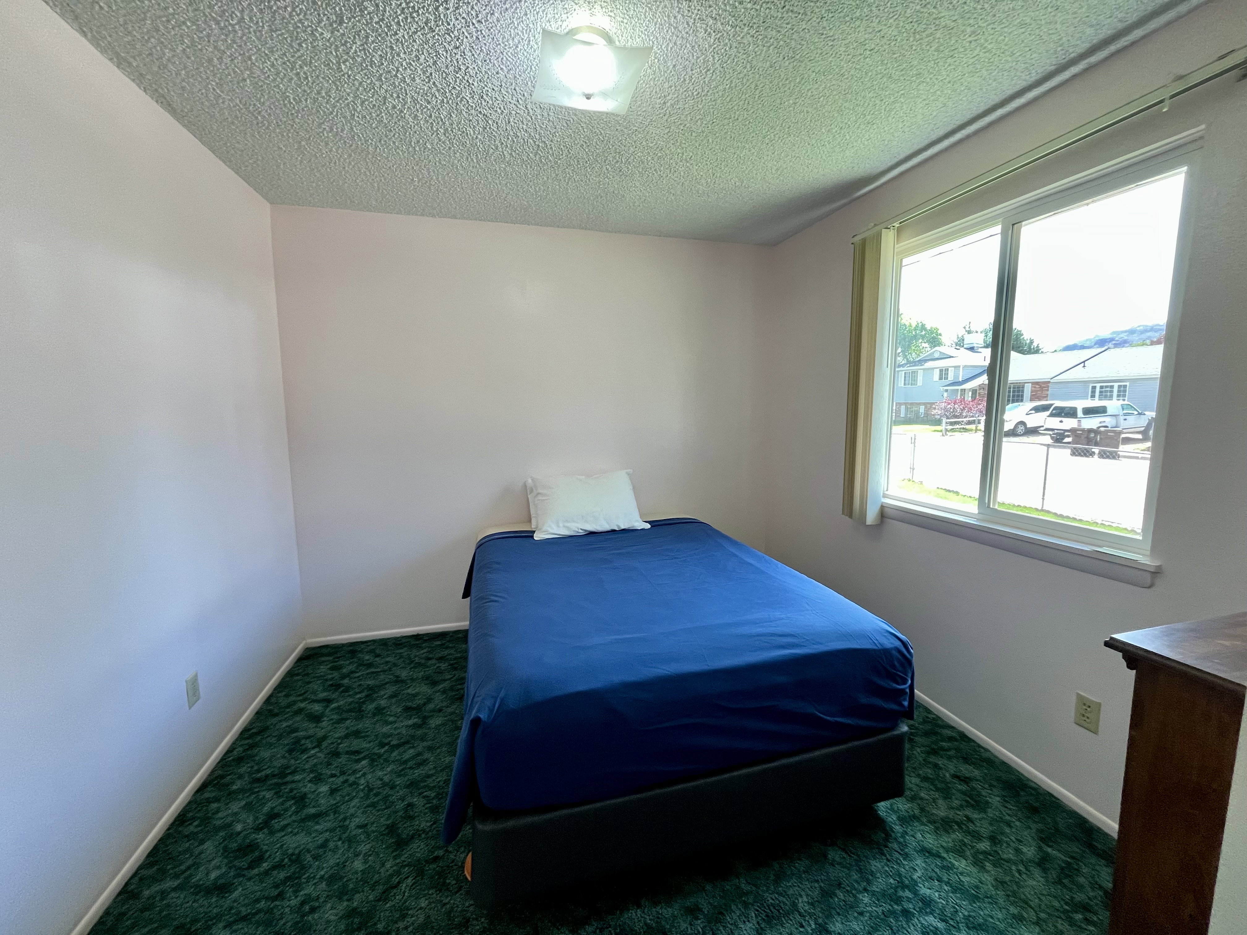 Bedroom featuring a textured ceiling and dark colored carpet