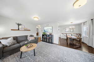 Living area with dark wood-type flooring and a chandelier