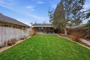 Rear view of property with a fenced backyard, a patio area, and brick siding