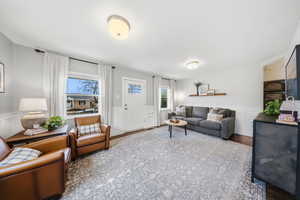 Living area with wainscoting, a decorative wall, and wood finished floors