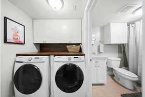 Laundry area featuring washing machine and dryer (excluded) and light tile patterned flooring