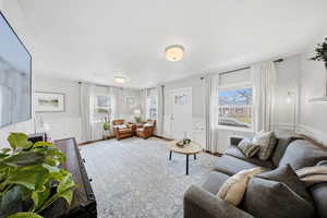 Living area featuring a decorative wall, wainscoting, plenty of natural light, and wood finished floors