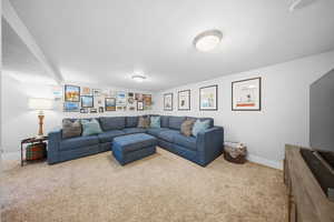 Living room featuring baseboards and light carpet