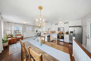 Dining space featuring hanging lights and dark wood-type flooring