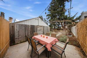 Fenced backyard with an additional patio area behind the garage, and outdoor dining area