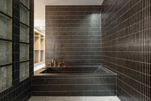 Full bathroom with tile walls