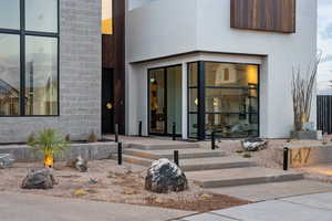 Doorway to property featuring stucco siding