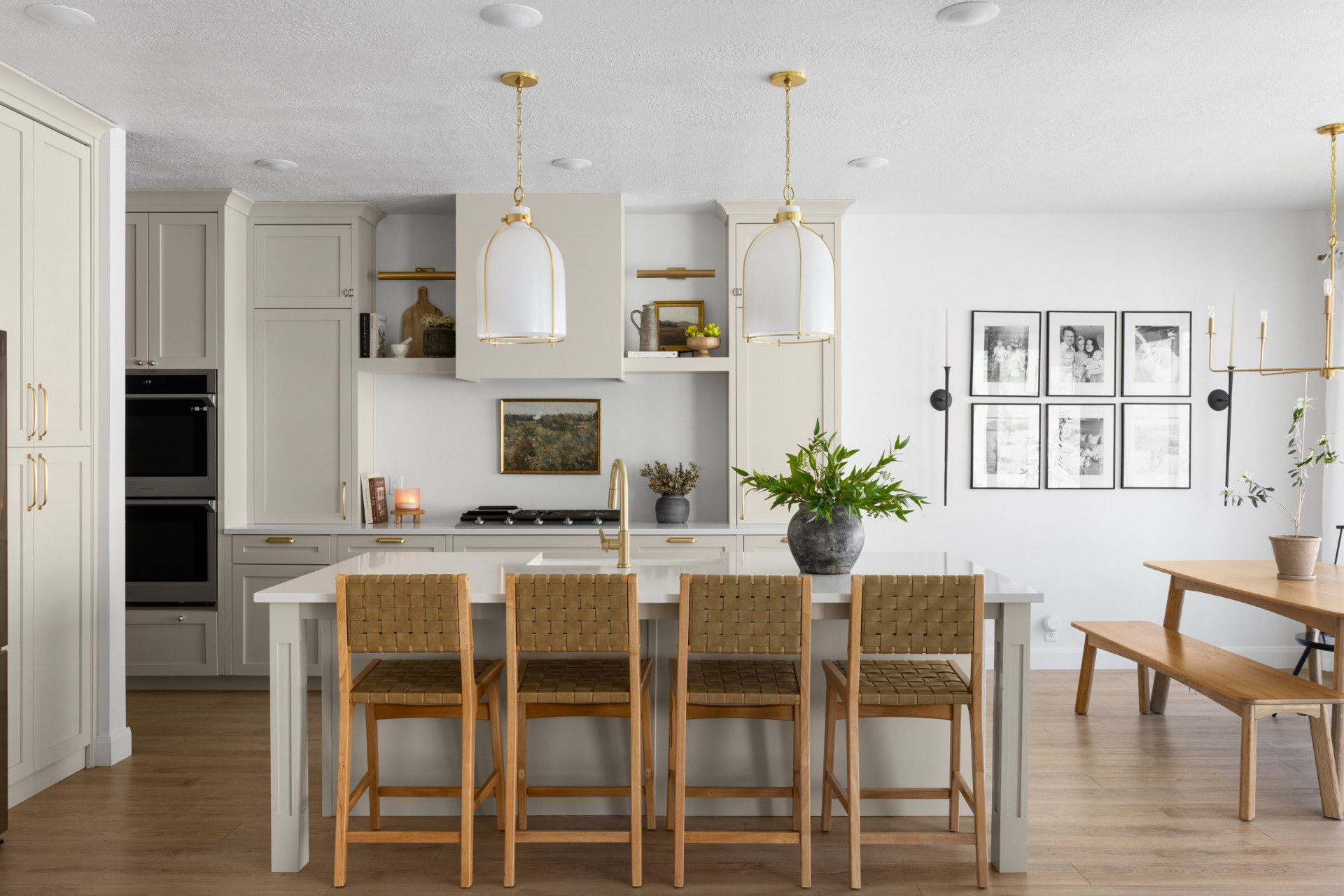 Well-appointed kitchen featuring a large island with seating, a gas range with a custom hood, integrated double ovens, and extensive cabinetry