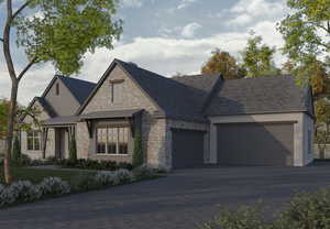 View of front of house with a garage, driveway, and stone siding