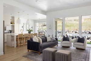 Open-concept living space featuring wood-finish flooring and multiple large windows