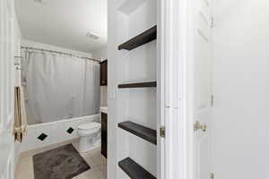 Full bathroom featuring shower / bathtub combination with curtain, light tile patterned floors, and vanity