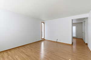 Unfurnished living room featuring wooden walls and wood finished floors