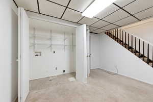 Laundry area featuring electric dryer hookup, carpet flooring, hookup for a washing machine, and a paneled ceiling