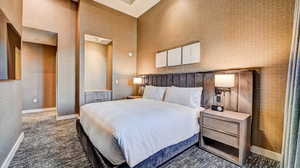 Bedroom with dark carpet and wallpapered walls