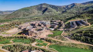 Aerial overview of property's location featuring a mountain backdrop and a golf course