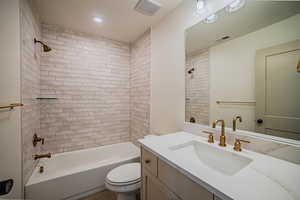Bathroom featuring vanity, shower / tub combination, and recessed lighting