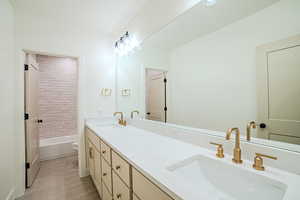 Bathroom with double vanity, light tile patterned floors, and tub / shower combination