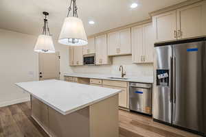 Kitchen featuring stainless steel appliances, light wood finished floors, and cream cabinetry