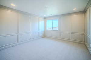 Empty room with a decorative wall, light carpet, and recessed lighting