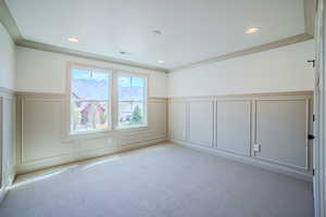 Empty room with a decorative wall, a wainscoted wall, light carpet, and recessed lighting