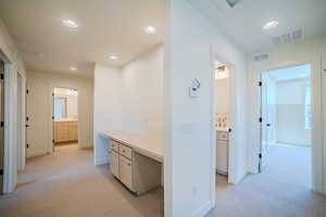 Hallway featuring light carpet, recessed lighting, and an office area