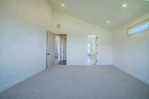 Unfurnished bedroom with light carpet, recessed lighting, and vaulted ceiling
