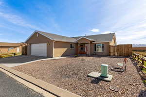Single story home featuring concrete driveway, a garage, stucco siding, and roof with shingles