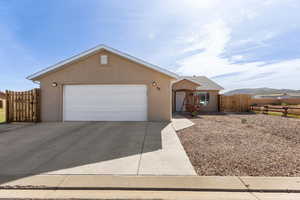 Ranch-style home featuring a gate, stucco siding, a garage, and concrete driveway