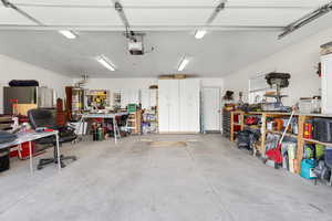 Garage featuring a workshop area, water heater, and a garage door opener