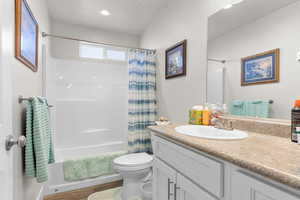 Full bath featuring vanity, shower / bath combination with curtain, wood finished floors, and recessed lighting