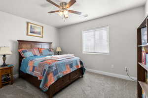 Bedroom with light colored carpet, ceiling fan, and a textured ceiling