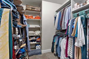Walk in closet featuring light colored carpet