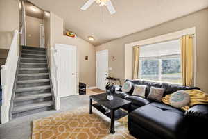 Living area with a ceiling fan and light colored carpet