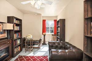 Office with a textured ceiling, light carpet, and a ceiling fan