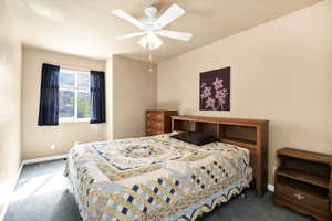 Carpeted bedroom with baseboards and ceiling fan