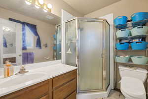 Full bath with a shower stall, vanity, and light tile patterned floors