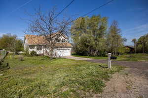 View of front of house featuring concrete driveway, a front lawn, and an attached garage